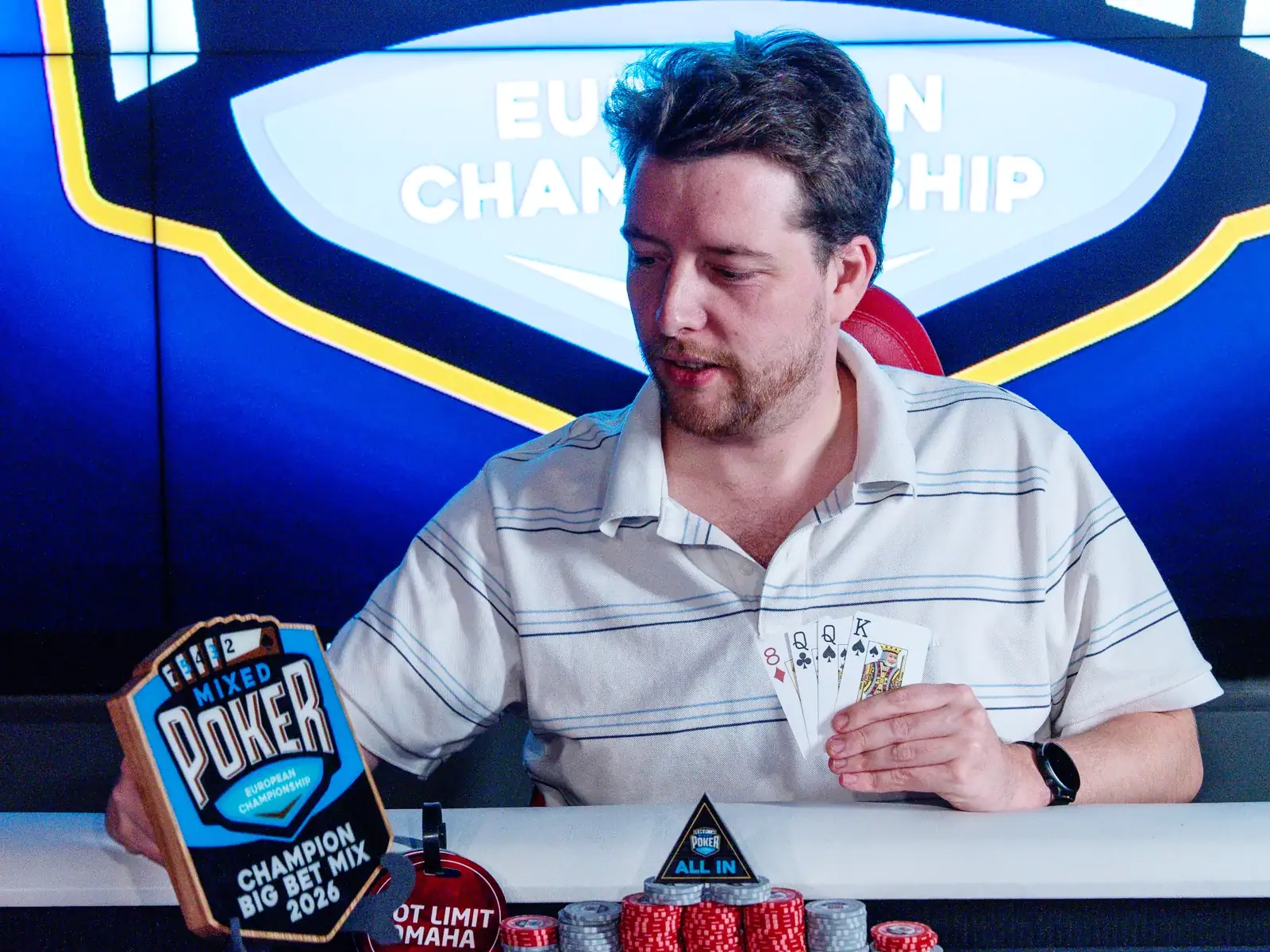 Christophe Stammet with the trophy and his final hand: K♠ Q♠ Q♣ 8♦ in Pot Limit Omaha.